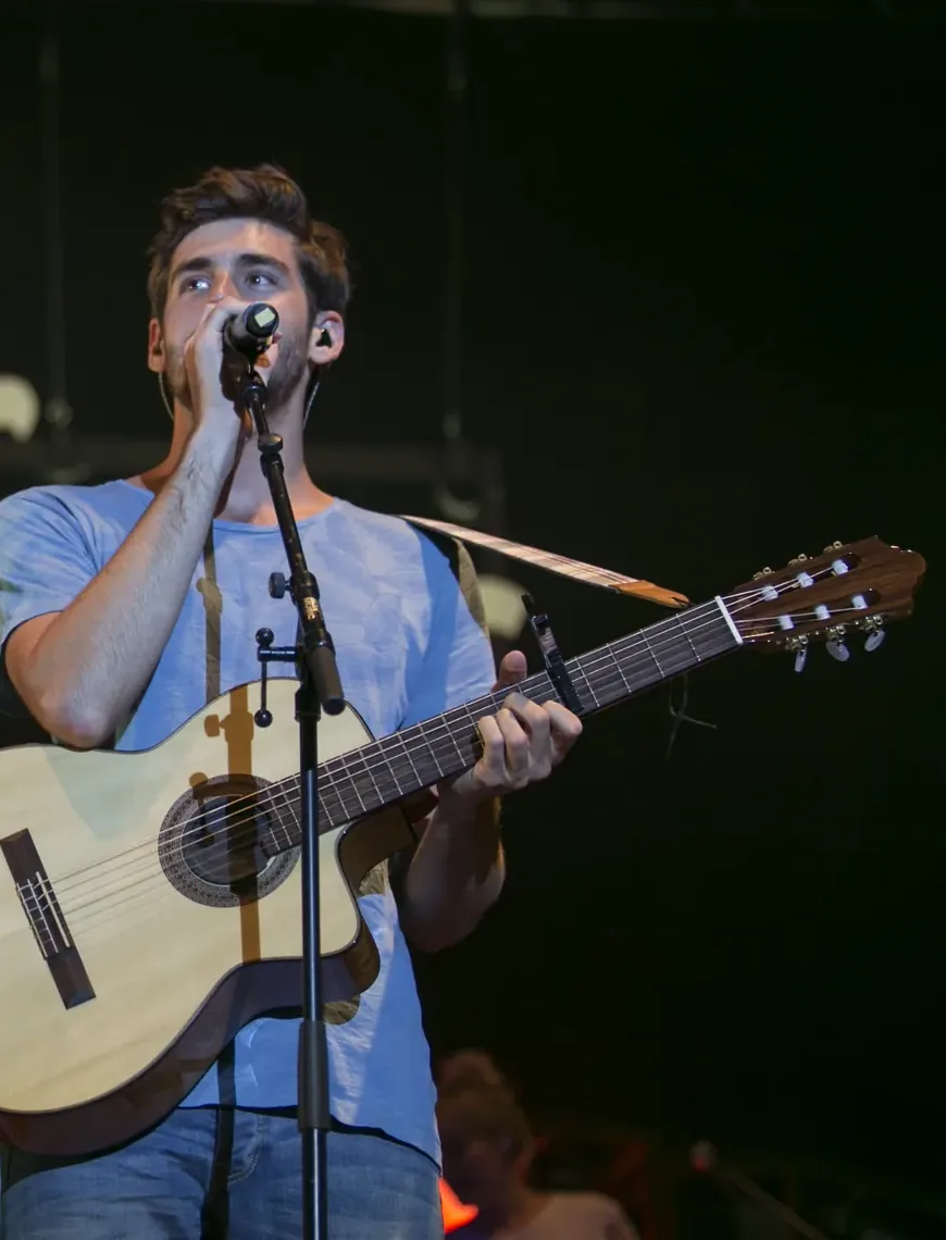 Cantante con chitarra sul palco