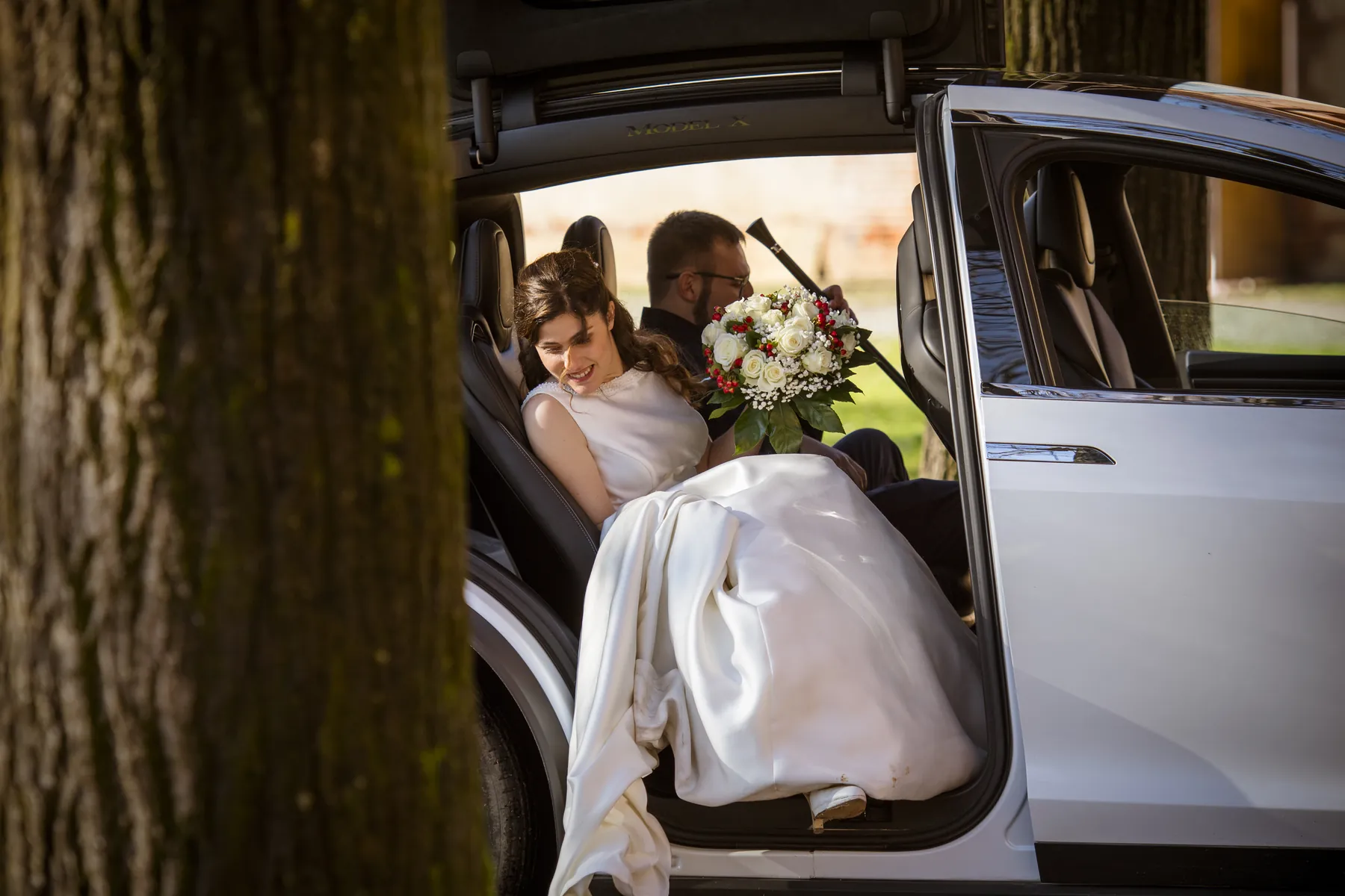 Sposi in auto con il bouquet