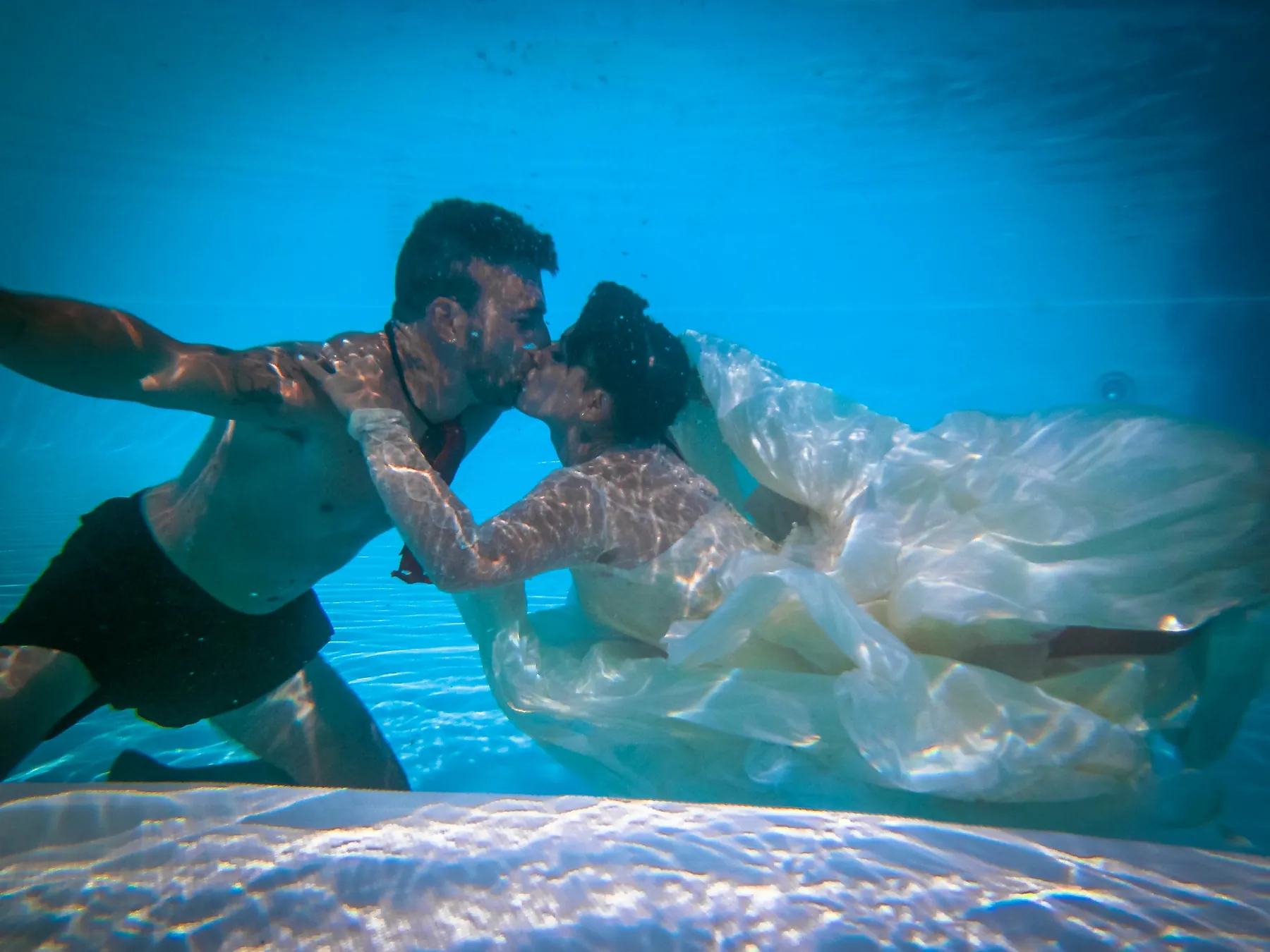 Sposi che si baciano sott’acqua in piscina