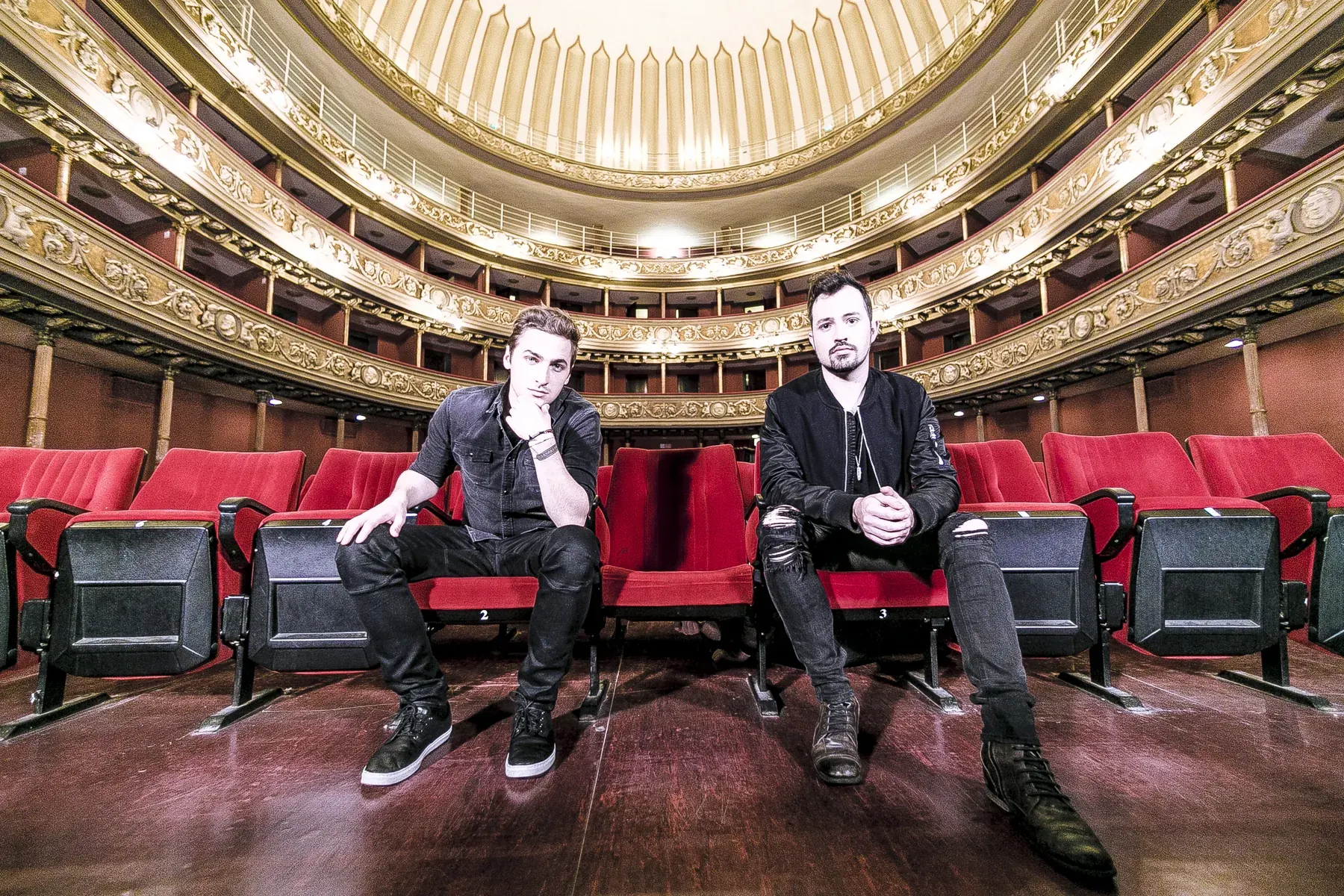 Due musicisti seduti in platea in un teatro storico