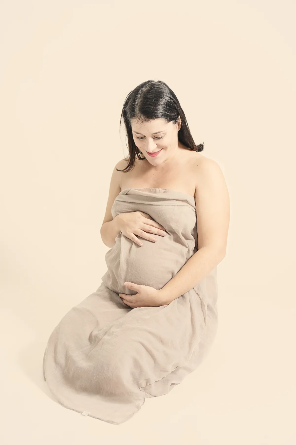 Futura mamma seduta con le mani sul pancione
