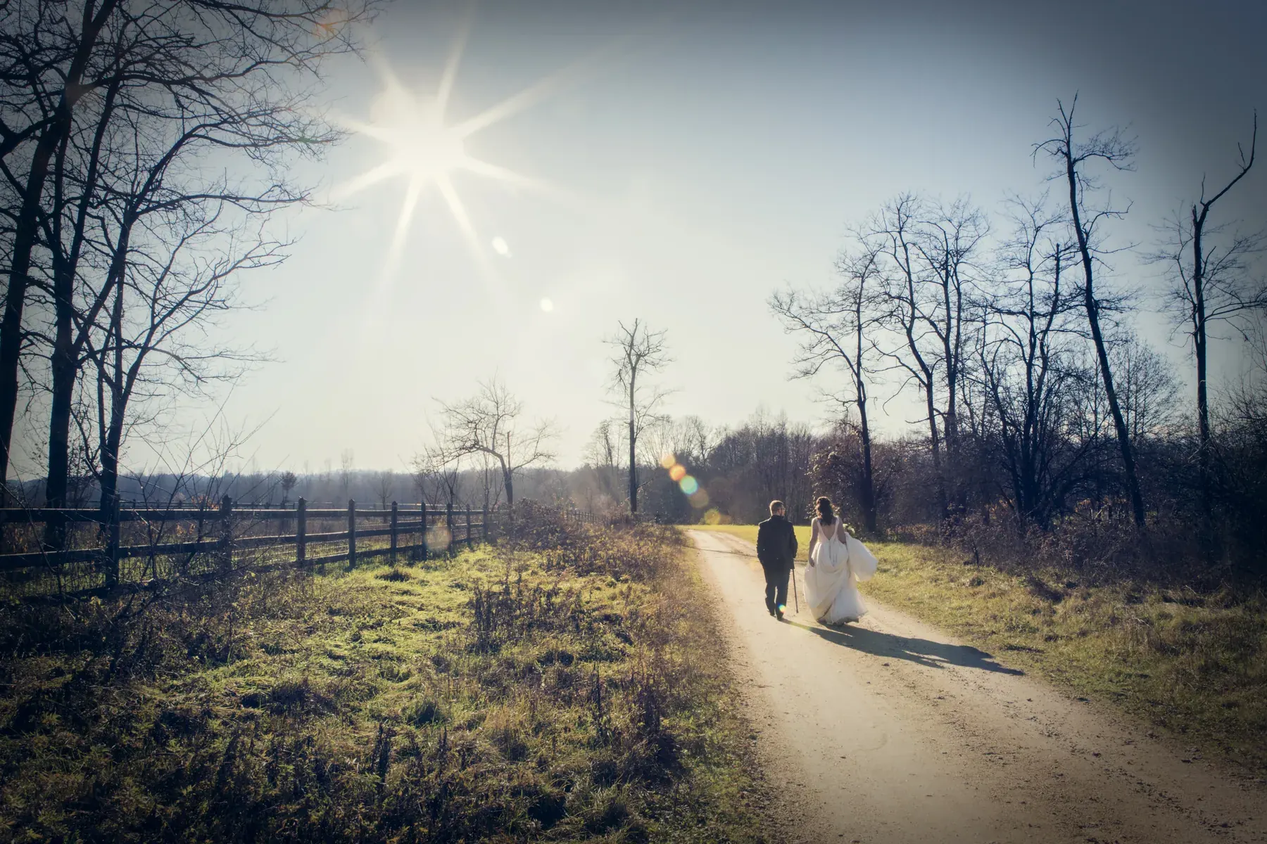 Sposi che camminano su un sentiero controluce