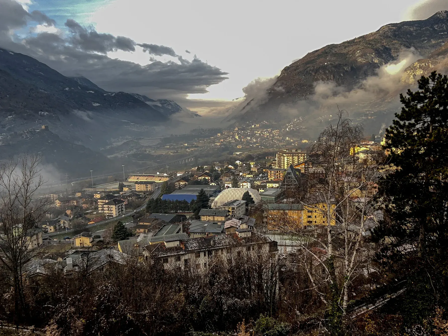 Valle alpina tra nuvole e nebbia